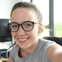 Pracowniczka Trusted Shops uśmiecha się do selfie.