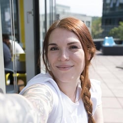 Pracowniczka Trusted Shops uśmiecha się do selfie.